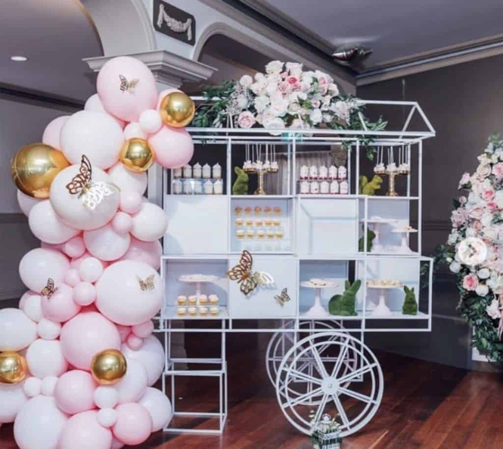 A balloon cart available for decoration hire, adorned with pink and white balloons.