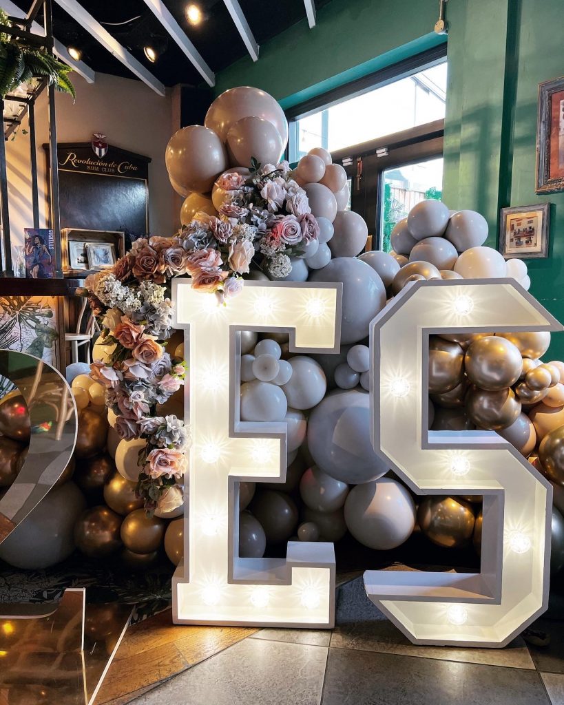 The number e is surrounded by balloons and flowers.