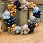 A balloon hoop made of blue and gold balloons.