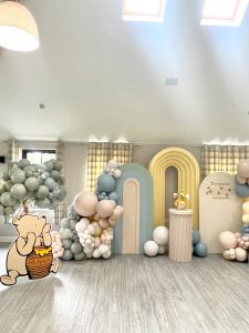 A room decorated with balloons and a teddy bear.