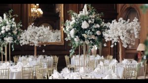 A wedding reception with white flowers in a large room.