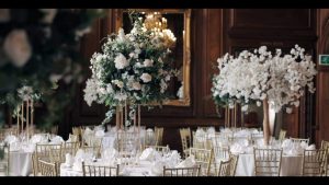 A wedding reception with white flowers and gold tables.