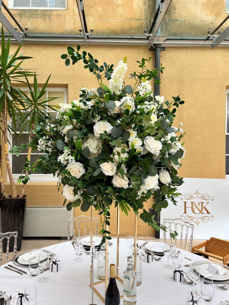 A table setting with white flowers and greenery.